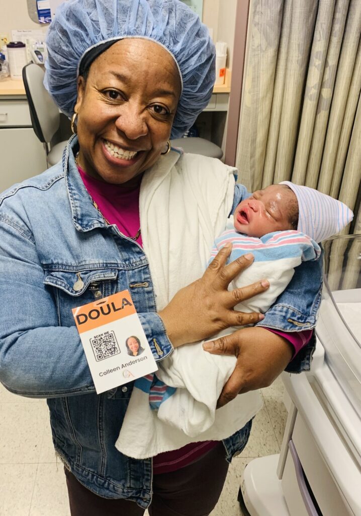 Colleen Anderson, certified New Jersey birth doula, holding a newborn after providing Medicaid-covered birth support
